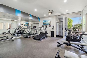 A spacious home gym with treadmills, elliptical machines, and other exercise equipment.